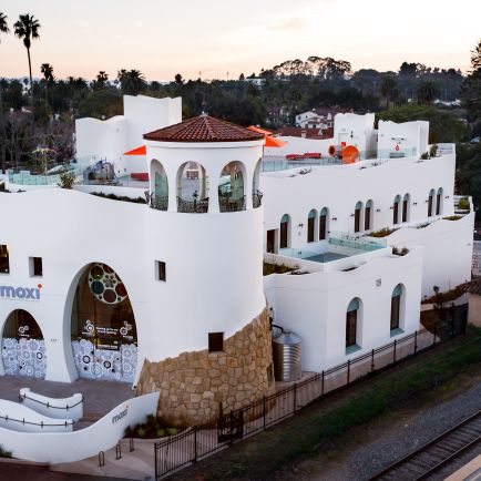 A white building situated adjacent to a train track, showcasing a blend of architecture and transportation infrastructure.