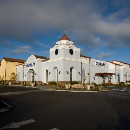 A white building stands against a clear blue sky, showcasing its elegant facade and bright surroundings.