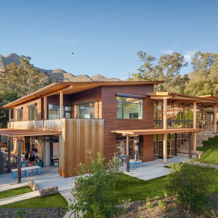 A modern building featuring a spacious deck and expansive lawn, ideal for outdoor activities and relaxation.