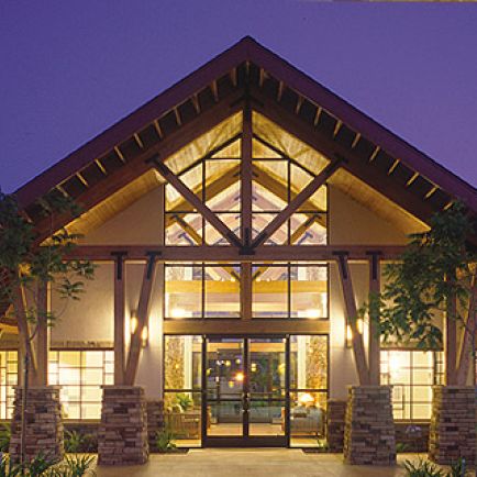 The illuminated entrance of a building at night, showcasing its architectural features and inviting atmosphere.