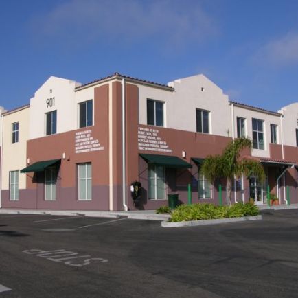 A tan and white building stands prominently, showcasing a blend of warm and neutral tones in its architecture.
