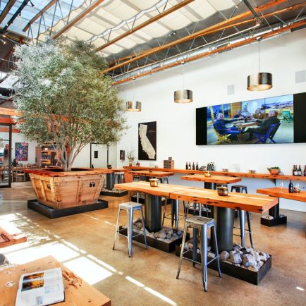 A winery interior featuring neatly arranged tables and chairs in the center of the room, creating a welcoming atmosphere.