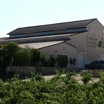A picturesque winery nestled in a quaint small town, surrounded by lush vineyards and charming landscapes.